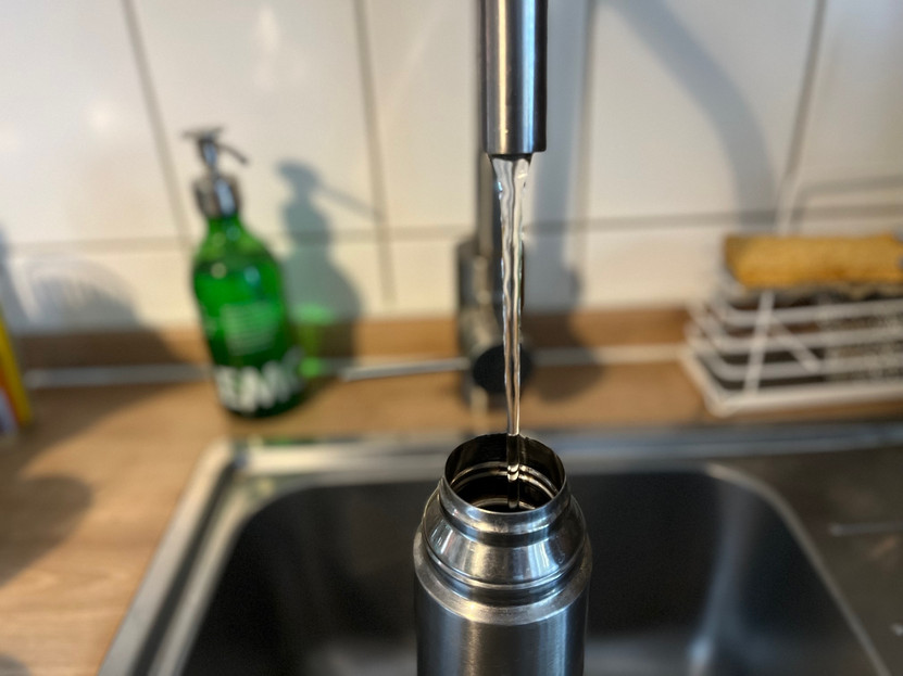 Leitungswasser fließt in eine Edelstahlflasche
