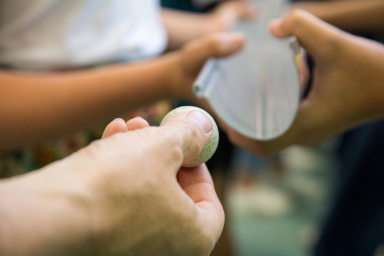 Hand führt Kugel in Rinne