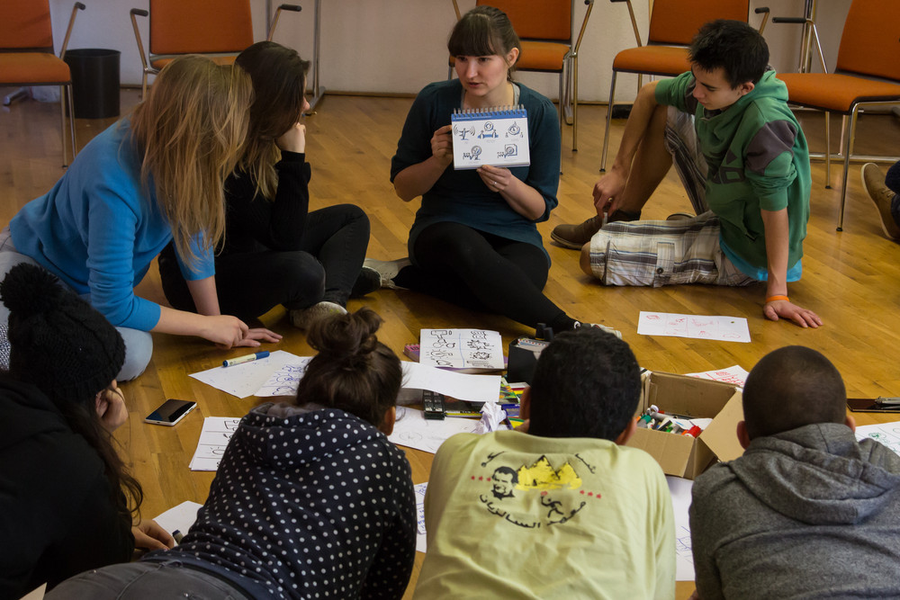 Jugendliche sitzen im Kreis und hören zu