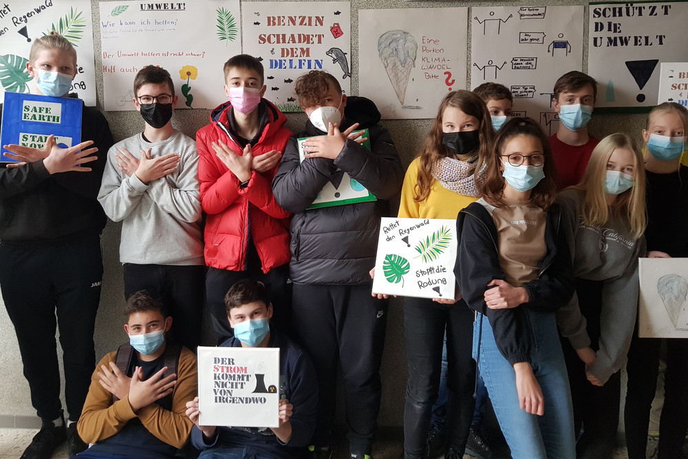 Klasse steht vor Wand mit Klimaplakaten